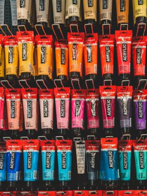 A vibrant array of acrylic paint tubes arranged neatly on a shelf.