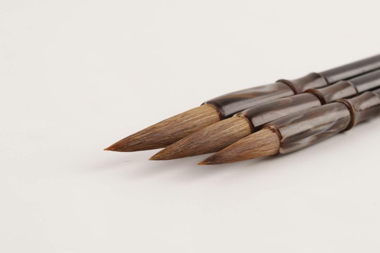 Close-up photograph of artist paint brushes on a white background, ideal for art-related projects.